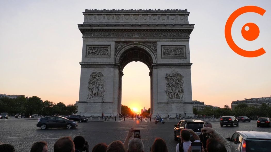 The sun sets in line with the Arc de Triomphe.